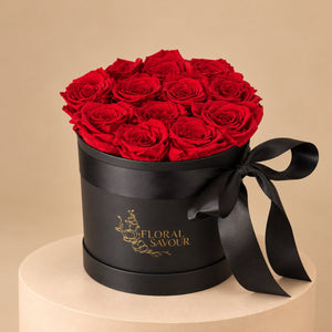 Dozen Forever Red roses in a black round flower box with a black ribbon


